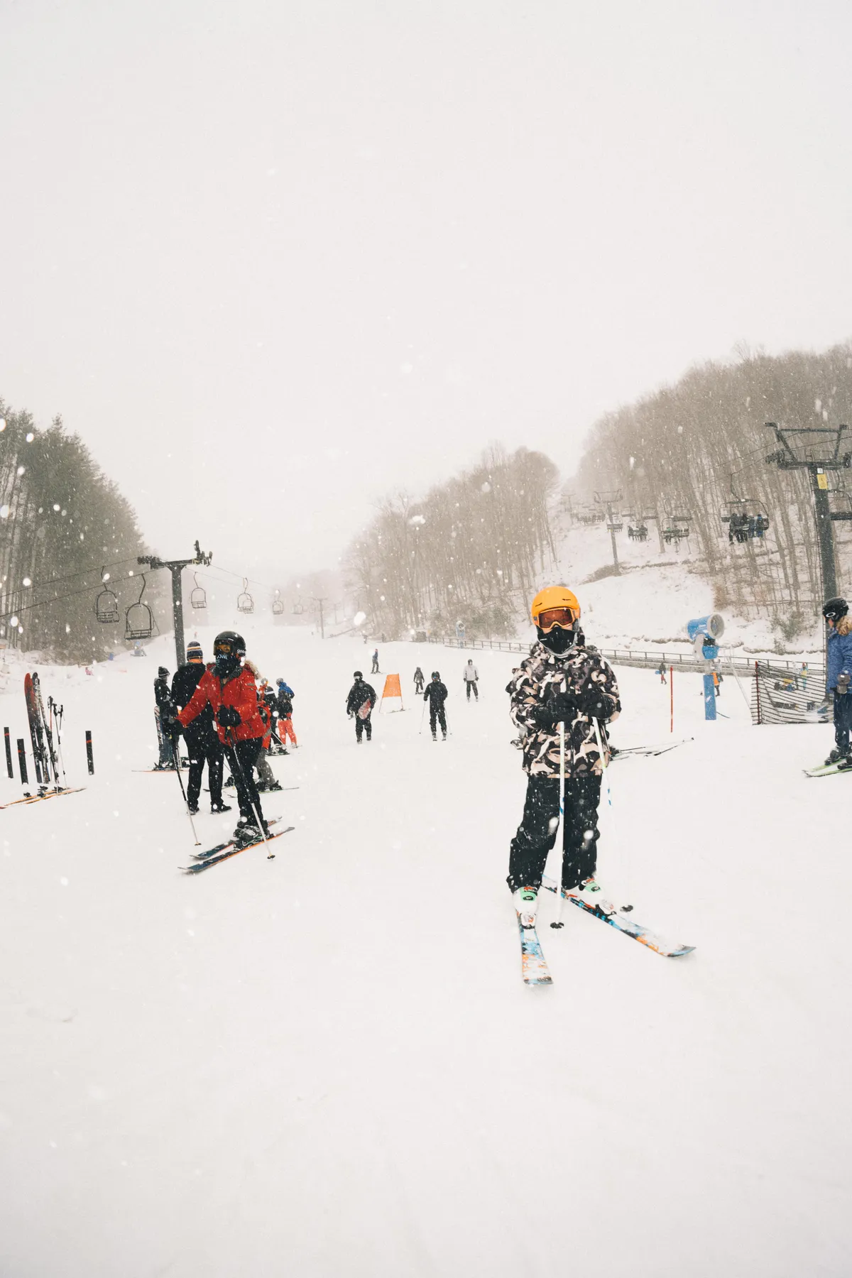 A vibrant exterior scene showing skiers navigating a snow-covered slope, with a ski lift ascending in the background. The landscape is blanketed in fresh snow, and the overall mood is energetic and joyful, capturing the excitement of winter sports and family adventure.